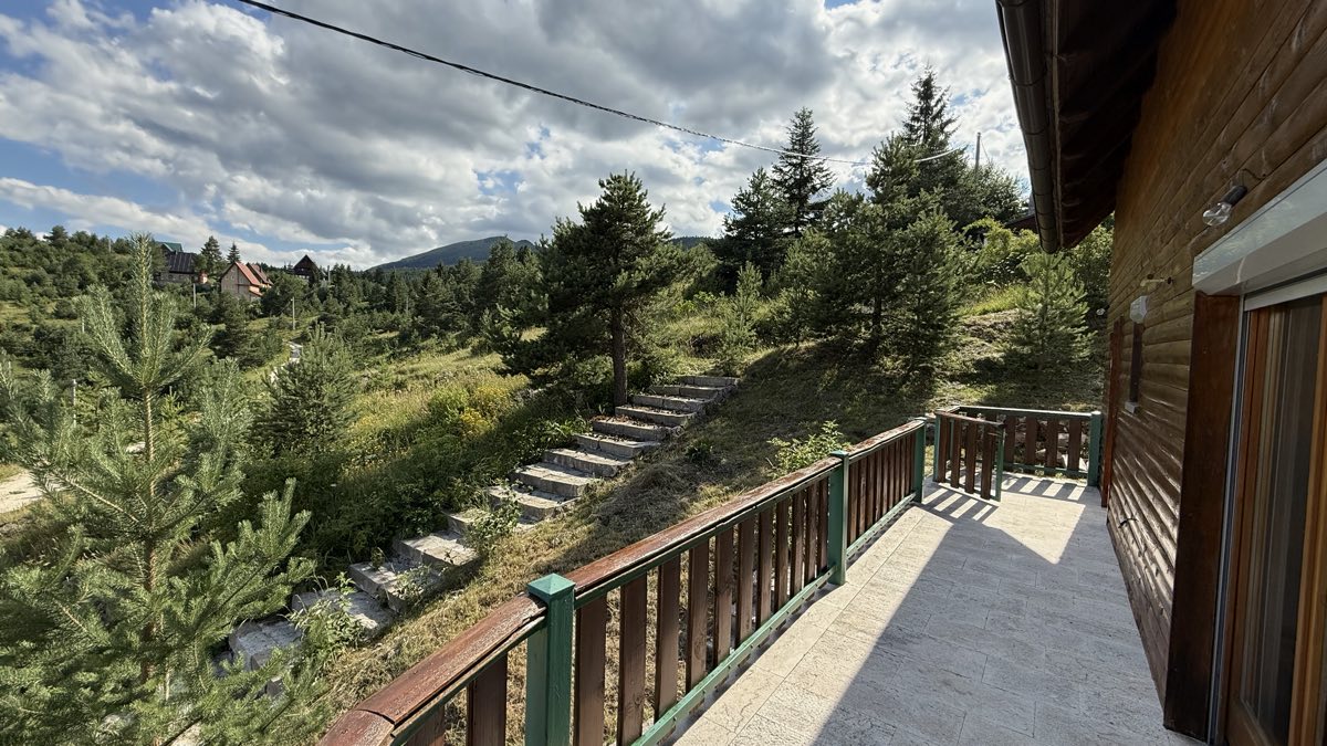 Balkon okružen zelenilom i borovima